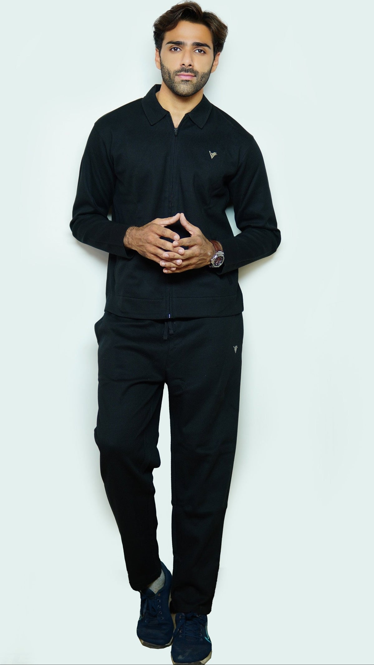 Man wearing a black outfit against a white background