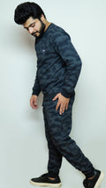 Man wearing a dark camouflage tracksuit against a white background
